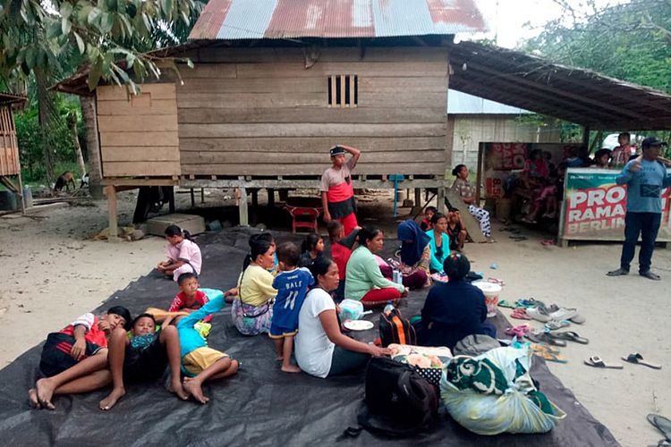 Warga berada di luar rumahnya pasca terjadi gempa bumi di kecamatan Sindue, Donggala, Sulawesi Tengah, Jumat (28/9/2018). Gempa bumi berkekuatan 5,9 skala richter dan susulan sebesar 7,7 skala richter mengguncang Donggala, Sulawesi Tengah.