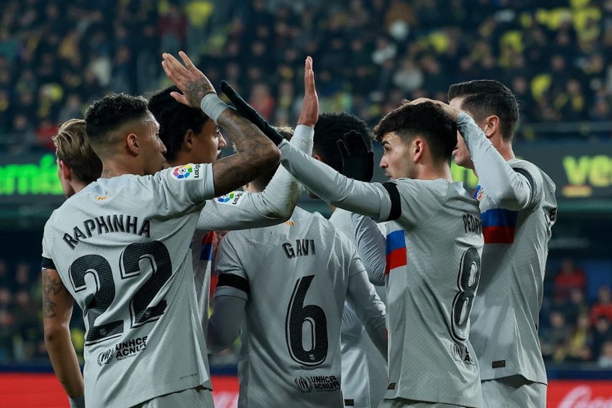 Para pemain Barcelona merayakan gol Pedri saat melawan Villarreal pada pekan ke-21 Liga Spanyol 2022-2023 di Stadion Ceramica, Senin (13/2/2023) dini hari WIB. Duel Villarreal vs Barcelona berakhir dengan skor 0-1. (Foto oleh JOSE JORDAN / AFP)