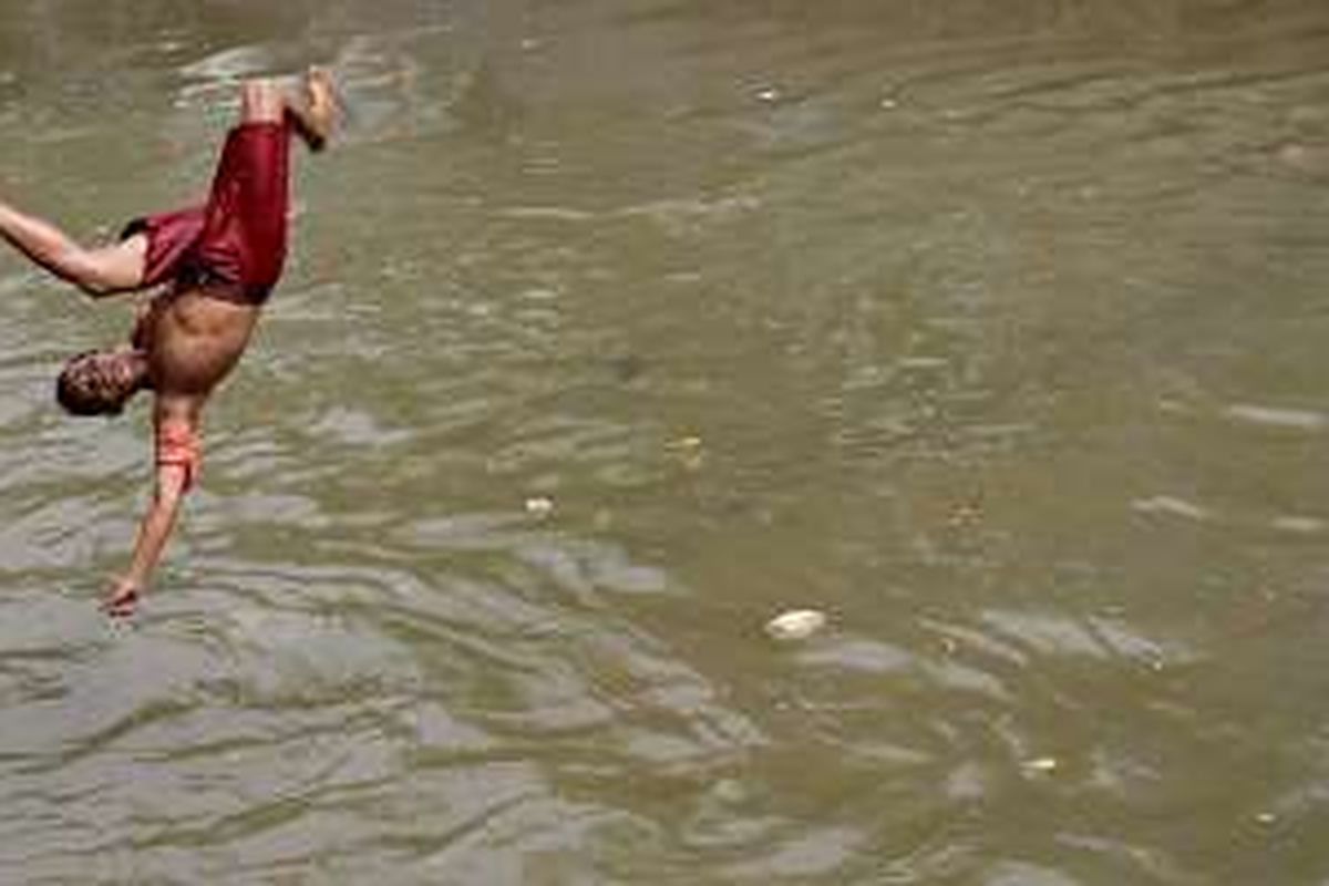 Bocah bermain di aliran anak Sungai Ciliwung di Jalan Labu, Kelurahan Mangga Besar, Jakarta Barat, yang tampak lebih bersih dibanding sungai-sungai Ibu Kota pada umumnya, Selasa (17/5/2016). Sejak setahun lalu, Pemerintah Provinsi DKI Jakarta mengutus Petugas Pelayanan Prasarana dan Sarana Umum (PPSU) DKI membersihkan sungai-sungai di Ibu Kota.