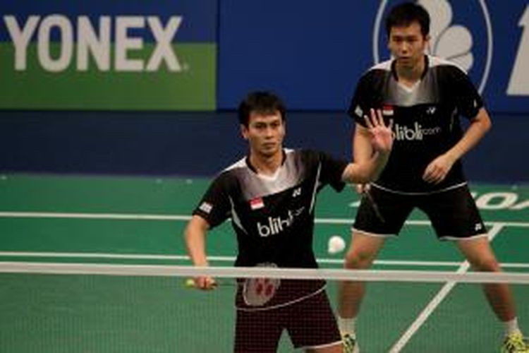 Ganda putra Indonesia, Mohammad Ahsan (depan)/Hendra Setiawan, melakukan servis ketika menghadapi ganda Gideon Markus Fernaldi/Markis Kido pada perempat final BCA Indonesia Open Superseries Permier 2014, Jumat (20/6/2014). Ahsan/Hendra menang 21-13, 21-23, 21-13. 