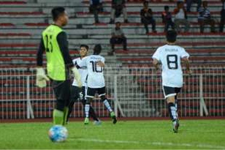 Makan Konate (10) memeluk Ahmad Takiyuddin, yang mencetak gol pembuka T-Team ke gawang ATM FA pada babak play-off di Stadion Perak, Sabtu (30/1/2016).