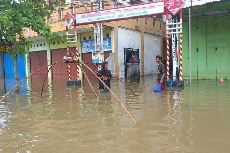Warga mencari ikan saat banjir di Jalan Raya Kaligawe Semarang, Jawa Tengah pada Jumat (15/3/2024).
