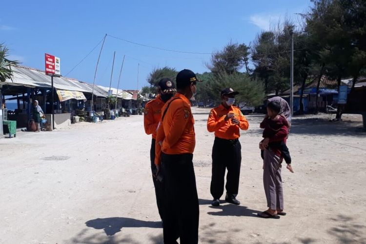 Petugas SAR Satlinmas Wilayah II Gunungkidul Memberikan Sosialisasi Prokes Kepada Wisatawan di Kawasan Pantai Sepanjang, Gunungkidul Jumat (14/5/2021)