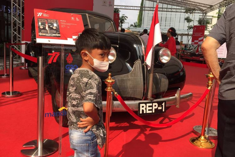 Seorang anak berpose di depan Buick-8, mobil kepresidenan pertama Republik Indonesia yang digunakan oleh Presiden Soekarno.