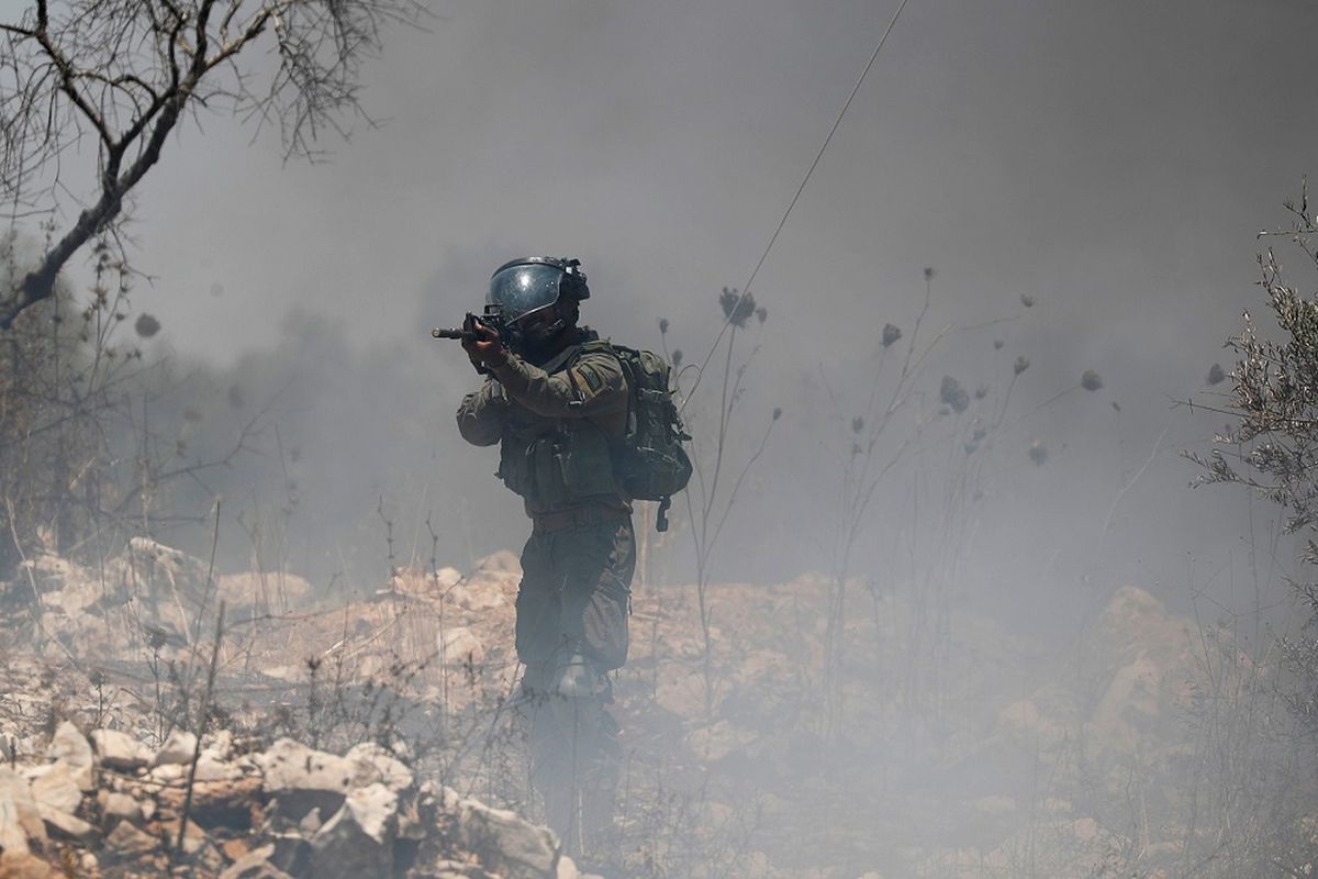 Anggota pasukan Israel membidikkan senjatanya ke arah pendemo Palestina saat aksi protes menentang rencana Israel menganeksasi bagian wilayah pendudukan Tepi Barat, di Kafr Qaddum dekat Nablus, Jumat (3/7/2020). ANTARA FOTO/REUTERS/Mohamad Torokman/pras/djo