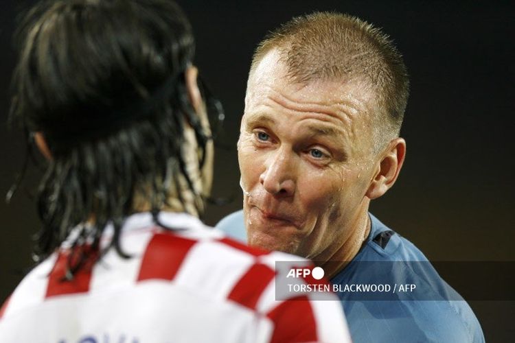 Wasit Graham Poll (kanan) berbicara dengan gelandang Kroasia, Niko Kovac, pada pertandingan melawan Australia di fase grup Piala Dunia 2006 yang digelar di Stadion Gottlieb-Daimler, 22 Juni 2006. Pada laga tersebut, Graham Poll memberikan tiga kartu kuning untuk Josip Simunic.