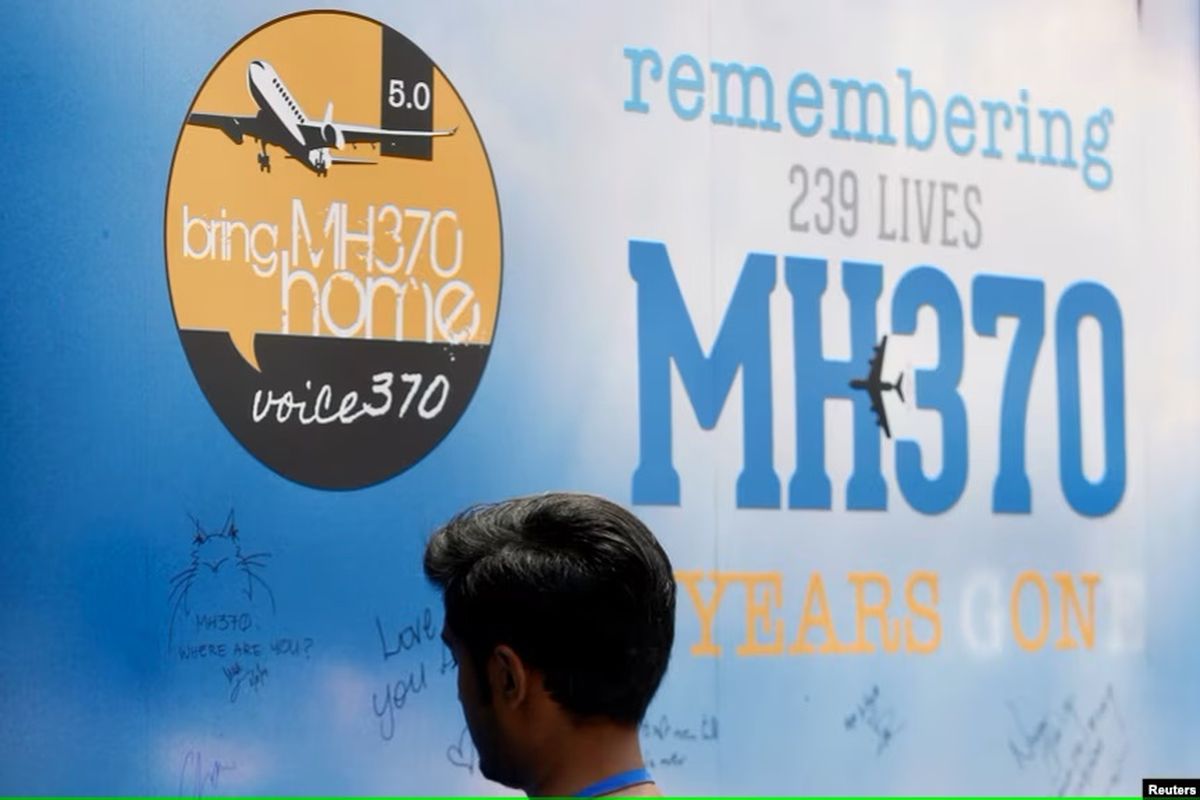 Seorang pria menulis di papan pesan untuk penumpang pesawat Malaysia Airlines Penerbangan MH370 yang hilang, pada acara peringatan tahunan kelima di Kuala Lumpur, Malaysia, 3 Maret 2019.