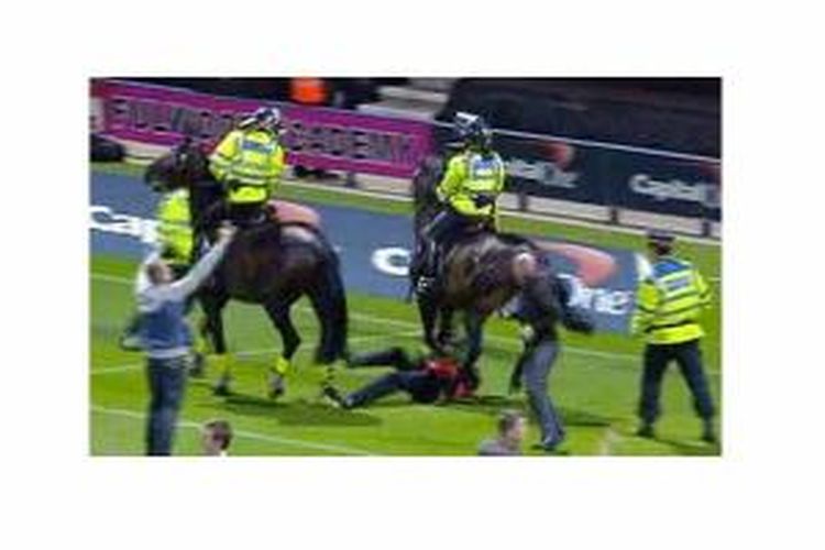 Foto yang memperlihatkan seorang panitia pertandingan diinjak kuda petugas keamanan.
