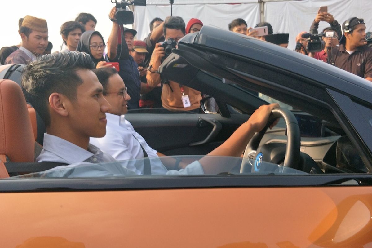 Gubernur DKI Jakarta Anies Baswedan disopiri pembalap Formula 2 Sean Gelael saat konvoi mobil listrik dari Kompleks Gelora Bung Karno (GBK) menuju kawasan Monas, Jakarta Pusat, Jumat (20/9/2019) sore.