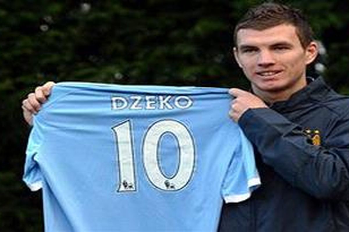 Edin Dzeko bangga menunjukkan seragam Manchester City bernomor 10.