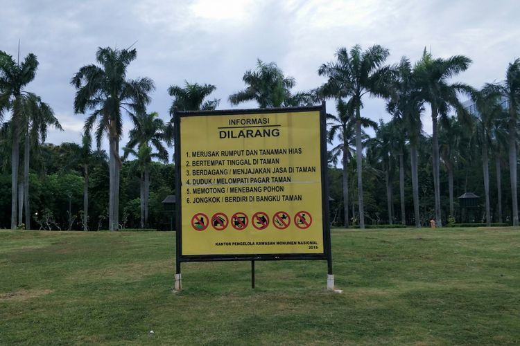 Pagar taman atau pagar pembatas rumput di kawasan Monas, Jakarta Pusat, telah dicopot. Namun, plang peringatan jangan merusak rumput masih terpasang. Foto diambil Kamis (11/1/2018).