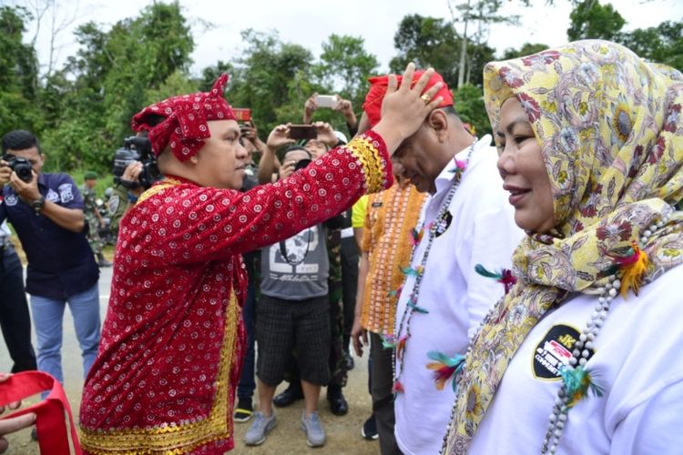 Gubernur Gorontalo, Rusli Habibie beserta sang istri, Idah Syaidah menerima topi adat atau Siga di perbatasan Sulawesi Selatan-Sulawesi Tengah, Minggu (23/02/2020).