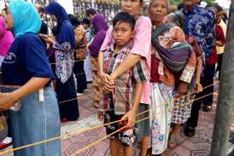 Sokirah (mengenakan jarik putih dengan mengendong barang) saat antri didepan gedung agung