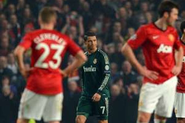 Cristiano Ronaldo (7) membela Real Madrid saat melawan Manchester United pada partai babak 16 besar Liga Champions di Stadion Old Trafford, 6 Maret 2013.