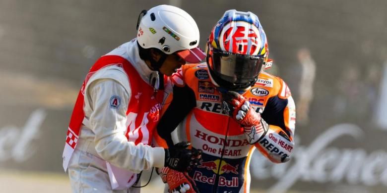 Pebalap Repsol Honda Team asal Spanyol, Dani Pedrosa (kanan), berjalan dengan dituntun marshal setelah terjatuh saat menjalani sesi latihan bebas kedua GP Jepang di Sirkuit Twin Ring Motegi, Jumat (14/10/2016).