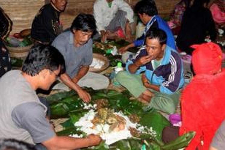 Tamu dan warga Lembah Bada berkumpul mengelompok masing-masing terdiri dari empat orang menikmati perjamuan makan modulu-dulu di Desa Lengkeka, Kecamatan Lore Barat, Poso, Jumat (30/8/2013). Modulu-dulu merupakan tradisi makan bersama Suku Lore khususnya etnis To Bada yang masih dipertahankan hingga sekarang.