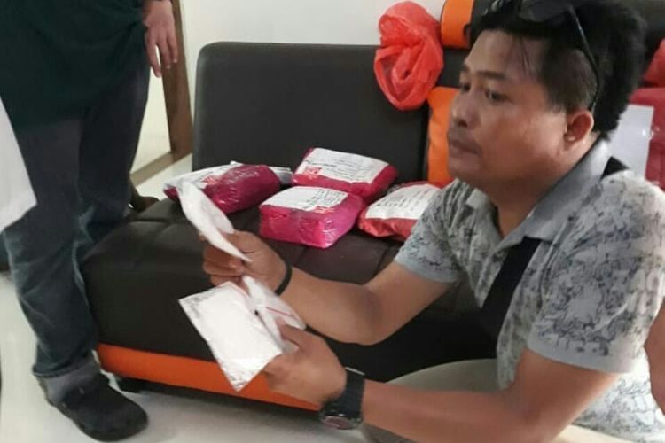 Petugas kepolisian menunjukkan sabu dalam beberapa sachet di rumah pemilik 5 kilogram sabu di Kendari. (Foto dokumen Humas Polda Sultral)