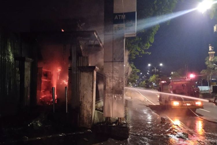 Petugas saat melakukan pemadaman api di gerai ATM BNI yang terbakar di Jalan Veteran, Gresik.