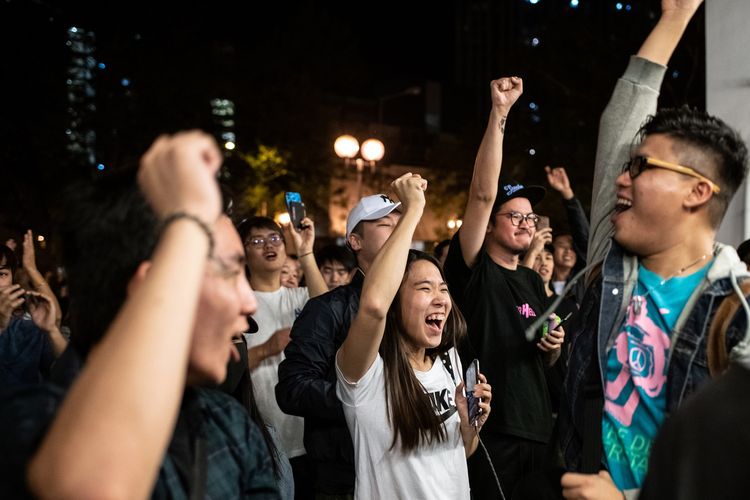 Pendukung pro-demokrasi bersorak di tengah merayakan kekalahan kandidat politisi pendukung China Junius Ho dalam pengumuman penghitungan pemilihan distrik yang digelar di Tuen Mun, Hong Kong, pada 25 November 2019. Mayoritas dari distrik dikuasai oleh kelompok pro-demokrasi.