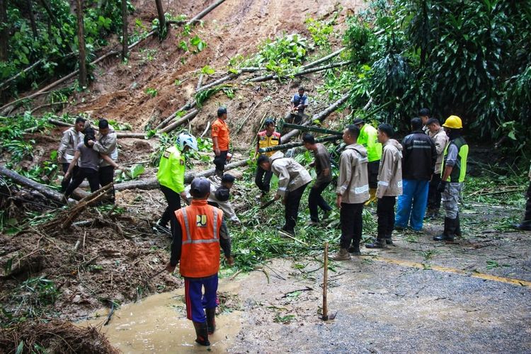 Sejumlah petugas membersihkan material longsoran di ruas Jalan Nasional Cibadak-Palabuhabratu di Kampung Cikananga, Desa Tonjong, Palabuhanratu, Sukabumi, Jawa Barat, Selasa (13/12/2022)