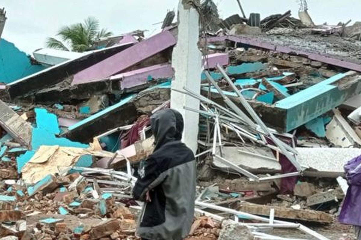 Locals of the West Sulawesi city of Mamuju stand in front of the ruins of the Mitra Manakarra Hospital after a 6.2 Richter scale earthquake hit the city and the eponymously named Mamuju Regency as well as the neighboring regency of Majene on Friday (15/1/21). The earthquake killed 84 people and injured more than 900 others