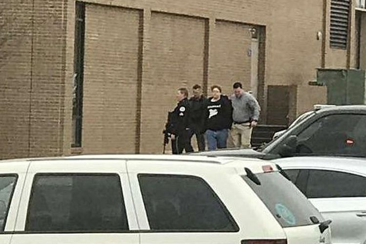 Polisi mengamankan seseorang (kedua dari kanan), keluar dari SMA Marshall County, setelah melakukan penembakan di sekolah tersebut pada Selasa (23/1/2018), di Benton, Kentucky, Amerika Serikat.