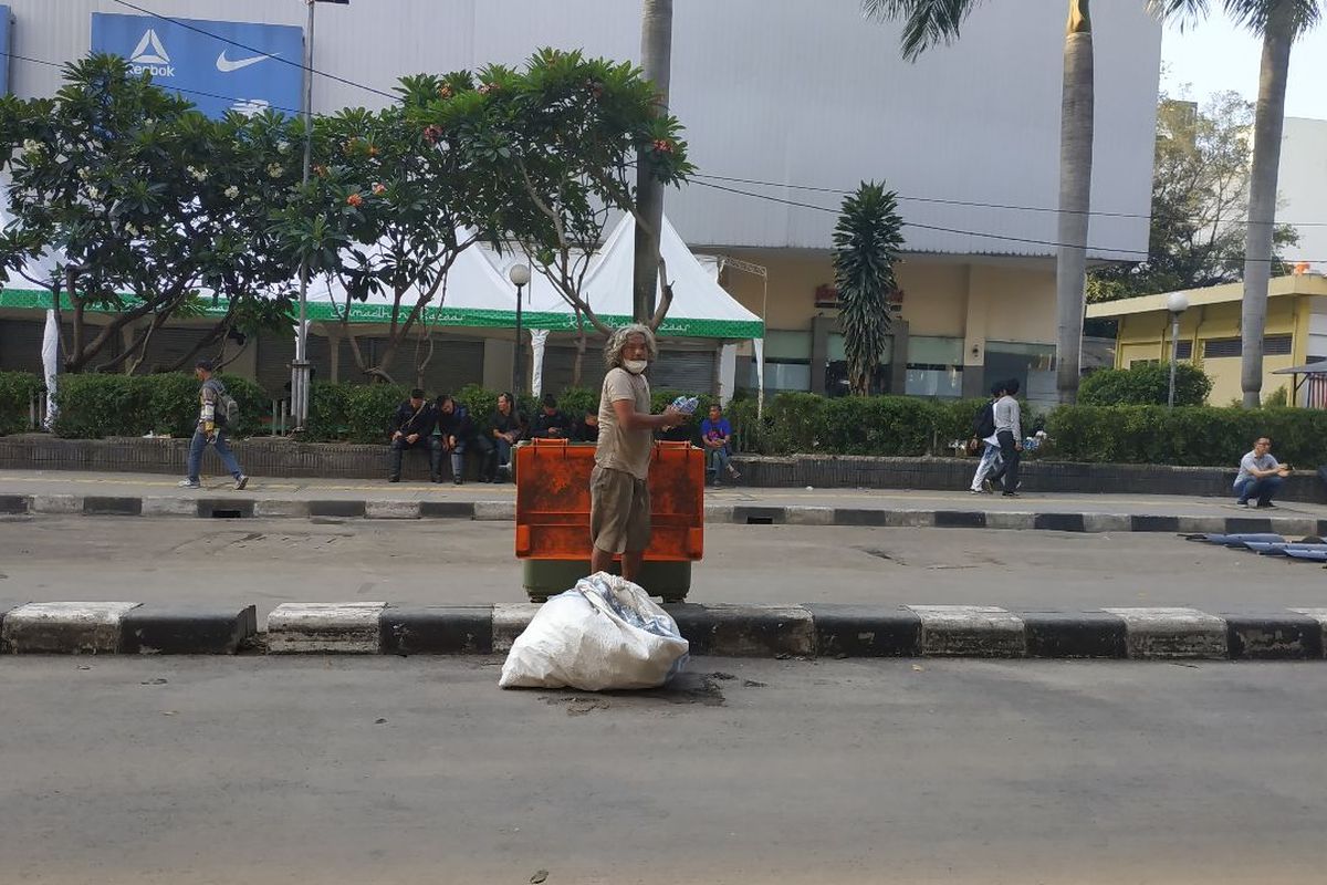 Seorang pemulung mengobok-obok bak sampah di Jalam KH Wahid Hasyim Jakarta Pusat seusai kericuhan yang berlangsung sampai Kamis (23/5/2019) subuh.