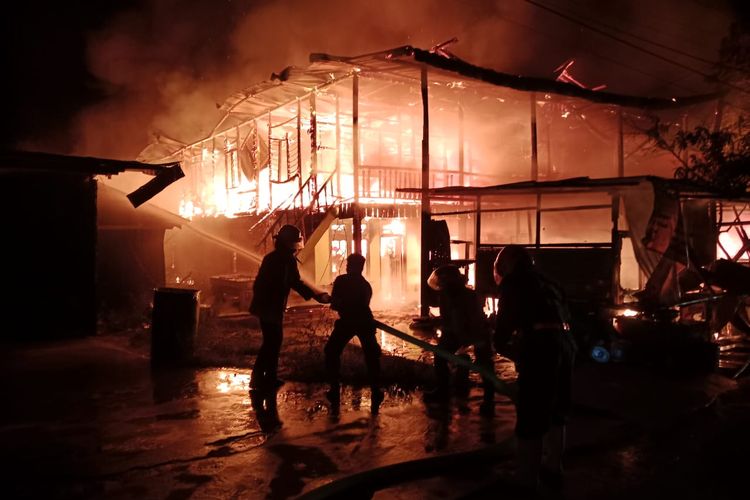 Petugas Damkar berjibaku memadamkan api yang melahap rumah panggung dua lantai yang juga menjadi rumah sewa bagi 7 KK di Pulau Sebatik, Nunukan, Kaltara