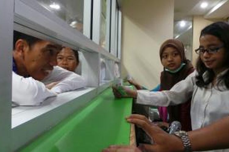 Gubernur DKI Jakarta Joko Widodo (kiri) meninjau loket pengambilan obat di RS Koja, Jakarta Utara, Jumat (13/12/2013).