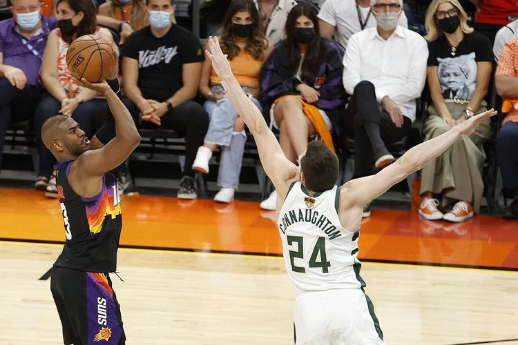 Pemain Phoenix Suns, Chris Paul, melancarkan tembakan saat mendapat hadangan dari pemain Milwaukee Bucks, Pat Connaughton, pada Gim 1 Final NBA di Phoenix Suns Arena, Arizona, Amerika Serikat, Rabu (7/7/2021) pagi WIB.