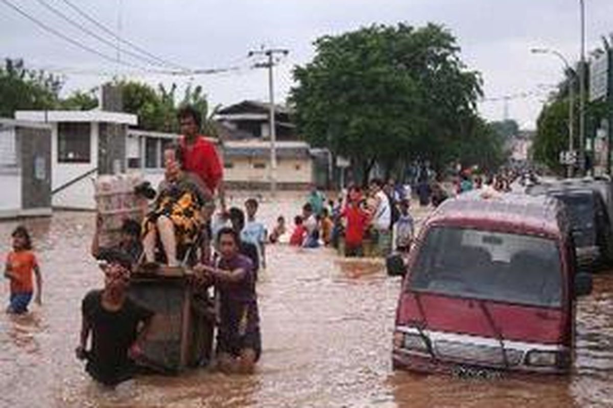 Gerobak yang biasanya bekerja sebagai pemulung kini beralih mata pencaharian, yaitu terpaksa digunakan untuk menyeberangkan warga yang terjebak banjir.