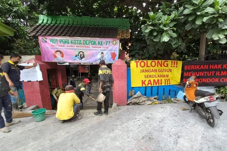 Dikeluhkan orangtua siswa lantaran revitalisasi trotoar Margonda lebih tinggi daripada permukaan sekolah, petugas Dinas PUPR Kota Depok tengah membuat akses jalan menuju SDN Pondok Cina 1, Beji, Depok pada Rabu (9/11/2022).