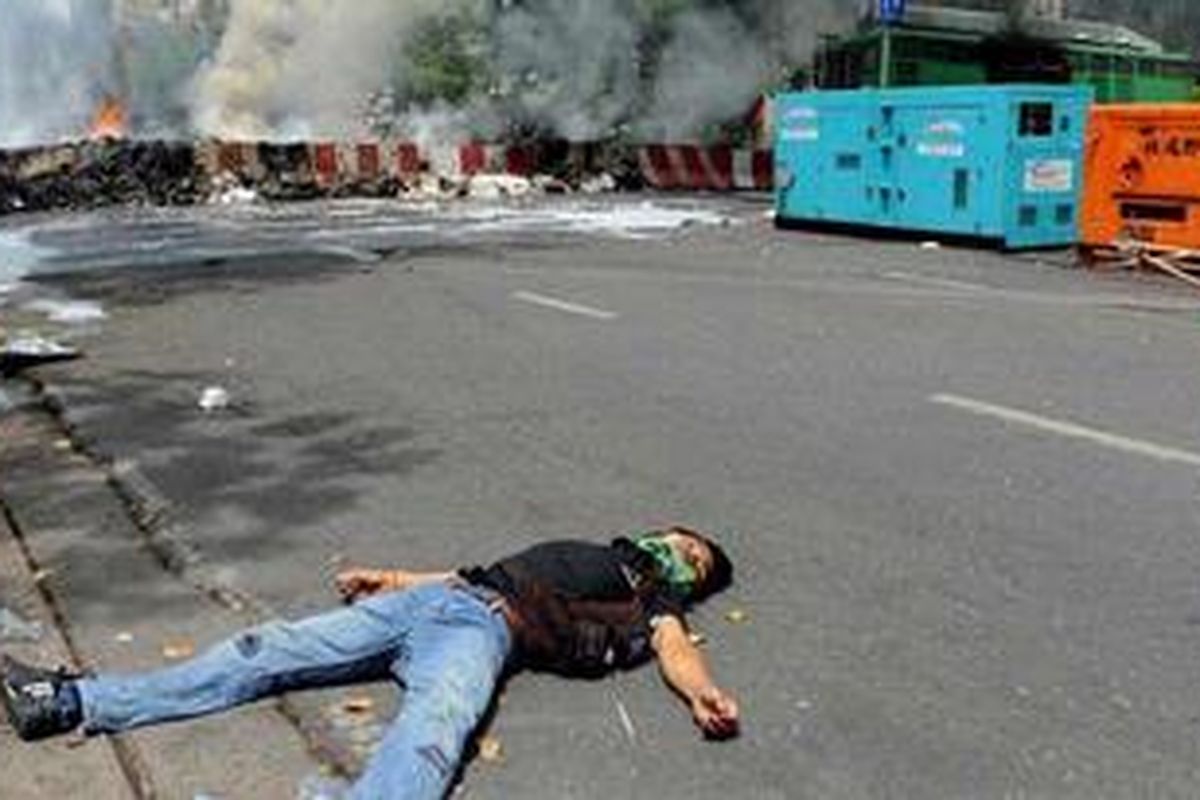 Pemrotes dari kelompok Kaus Merah tergeletak mati di jalan dekat kamp mereka di Bangkok, Rabu (19/5/2010).