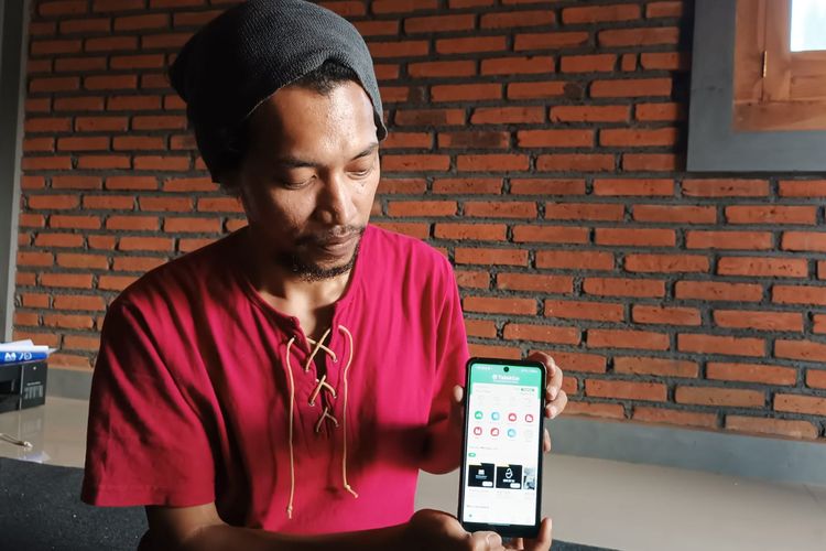 Evan Helga (32), warga Desa Talok, Kecamatan Turen, Kabupaten Malang menunjukkan aplikasi Talok Go buatannya untuk mewadahi UMKM Desa.