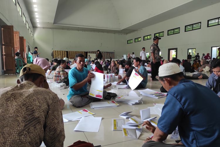 Para petugas melipat surat suara DPR RI di Gedung Ikatan Persaudaraan Haji Indonesia (IPHI) Kabupaten Demak, Kamis (4/1/2024). (KOMPAS.COM/NUR ZAIDI) 
