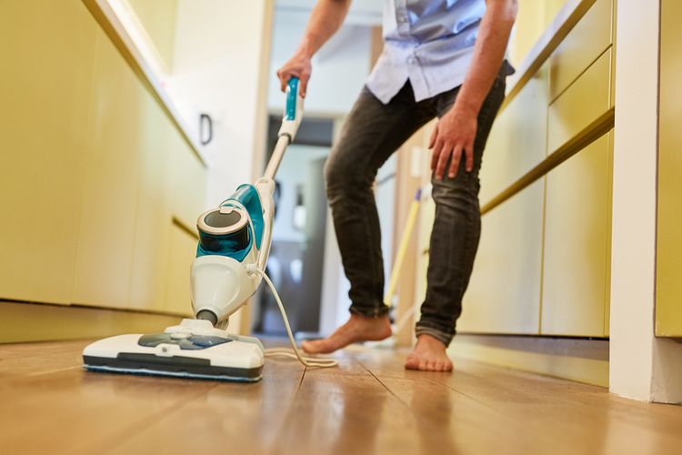 Ilustrasi membersihkan lantai dengan steam mop atau pel uap.
