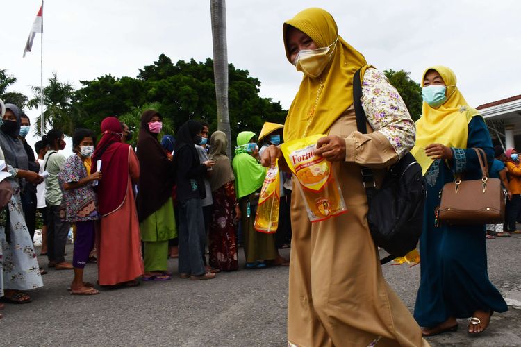 Warga membawa minyak goreng yang dibeli saat operasi pasar minyak goreng di halaman pendapa Bakorwil Madiun, Jawa Timur, Selasa (15/2/2022). Operasi Pasar Minyak Goreng Murah bersama Gubernur Jawa Timur Khofifah Indar Parawansa tersebut menyediakan sekitar tiga ribu liter minyak goreng kemasan yang dijual dengan harga Rp 12.500 per liter dan setiap pemilik KTP mendapat jatah dua liter.