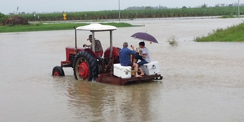 Selain menggunakan perahu, warga juga memanfaatkan traktor untuk pergi ke bar.