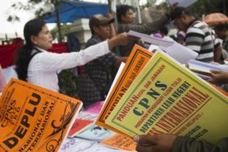 Pedagang menawarkan buku panduan seleksi calon pegawai negeri sipil (CPNS) di depan Gedung Cakara Loka Departemen Luar Negeri, Jakarta Pusat, Senin (3/9/2012). Seleksi CPNS Deplu dimanfaatkan para pedagang dadakan untuk menjual buku panduan seharga Rp 20.000 per buku.