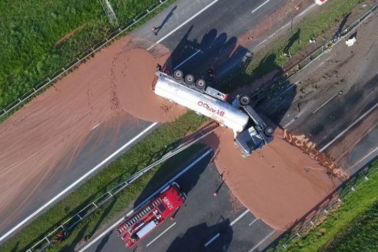 Cokelat tumpah di atas jalan raya  antara Wrzesnia dan Slupca dekat Poznan, Polandia barat, setelah truk pengangkut barang terguling pada Rabu (9/8/2018). (AFP/STR/TVN)