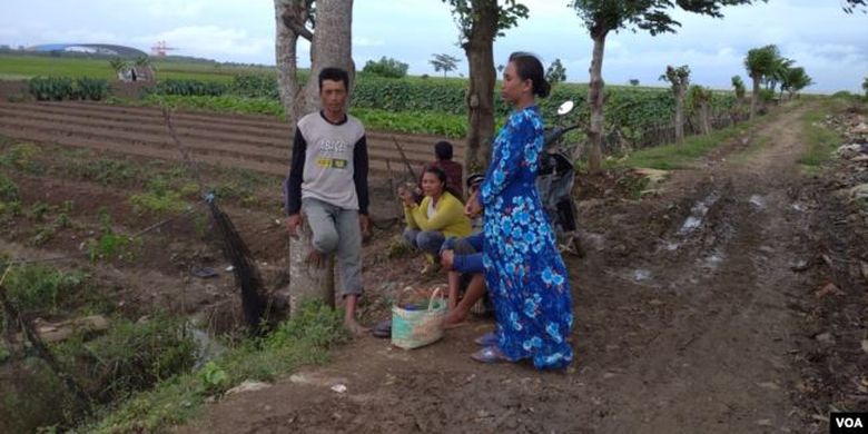 Sutini (baju biru) yang tengah menengok sawah miliknya di dekat PLTU Indramayu, Sabtu (29/2/2020)