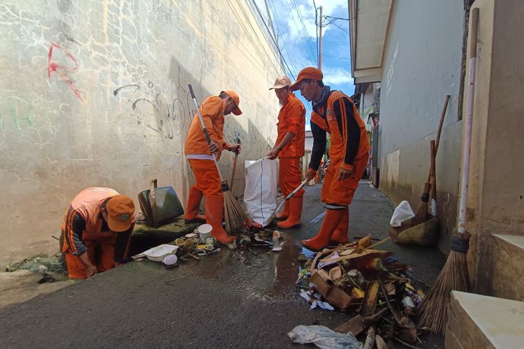 Petugas PPSU Kelurahan Kampung Rambutan membersihkan berbagai jenis sampah pascabanjir di Kawasan RT 04 dan RT 12 RW 02, Kelurahan Kampung Rambutan, Kecamatan Ciracas, Jakarta Timur, Senin (20/2/2023).