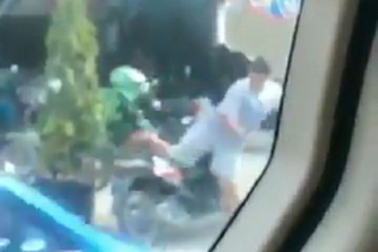 Tangkapan layar saat pengemudi ojol dihantam seorang pria mengenakan celana pendek dan baju kaus biru di Jalan  Cempaka, Kecamatan Sukajadi, Kota Pekanbaru, Riau, viral di media sosial, Sabtu (4/7/2020).