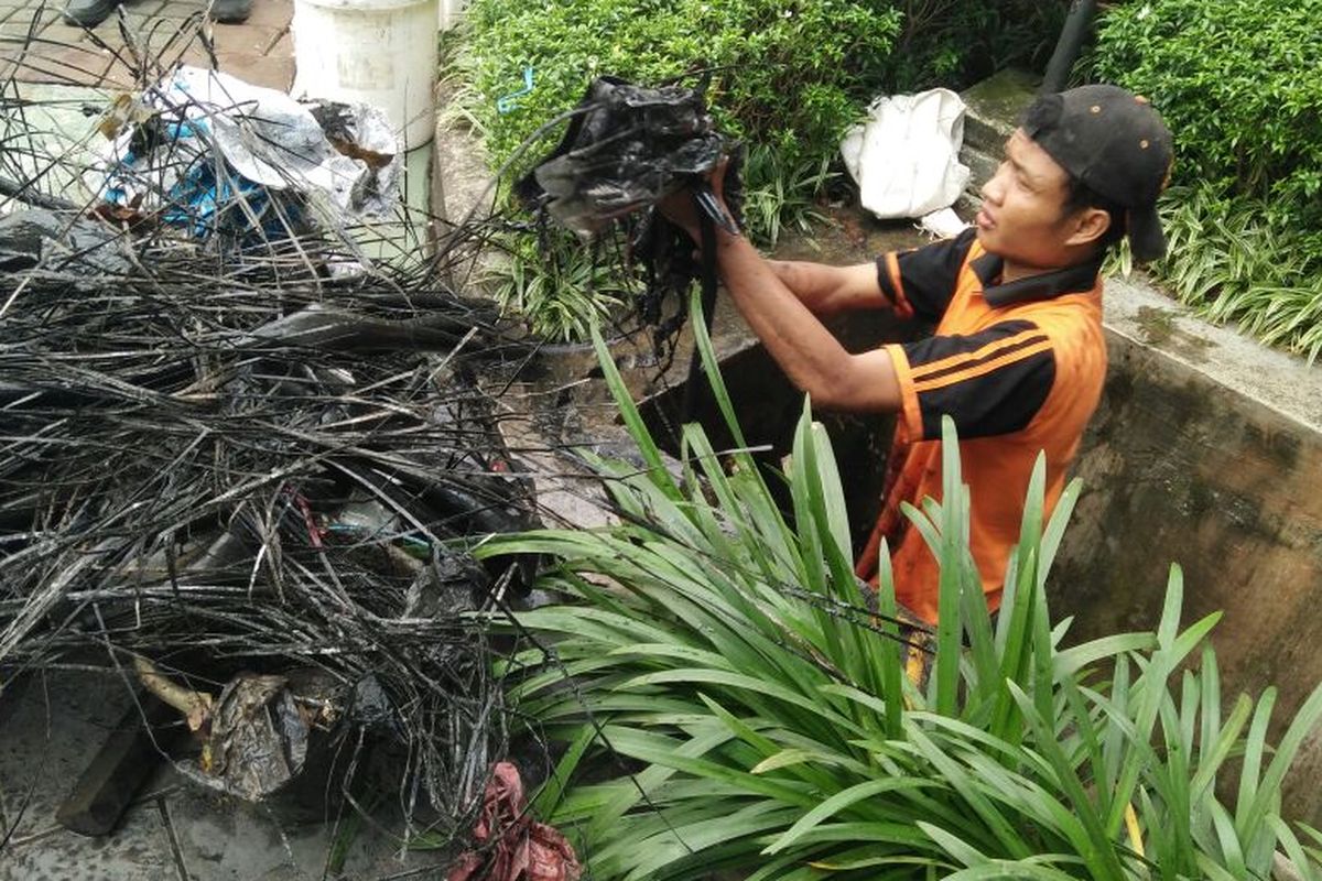 Pasukan oranye atau petugas PPSU Kelurahan Kuningan Barat menemukan gulungan kulit kabel, di gorong-gorong Jalan Gatot Subroto, Jakarta Selatan. 