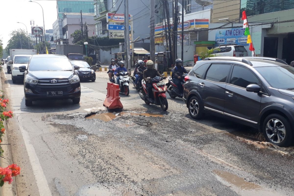 Tampak kondisi jalan KH. Noer Ali tepatnya di depan Rumah sakir Budi Lestari berlubang besar sebabkan arus lalu lintas tersendat cenderung macet, Kota Bekasi, Senin (27/8/2018).