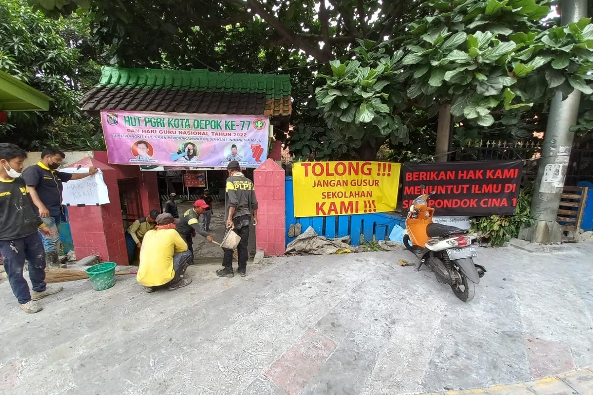 Dikeluhkan orangtua siswa lantaran revitalisasi trotoar Margonda lebih tinggi daripada permukaan sekolah, petugas Dinas PUPR Kota Depok tengah membuat akses jalan menuju SDN Pondok Cina 1, Beji, Depok pada Rabu (9/11/2022).