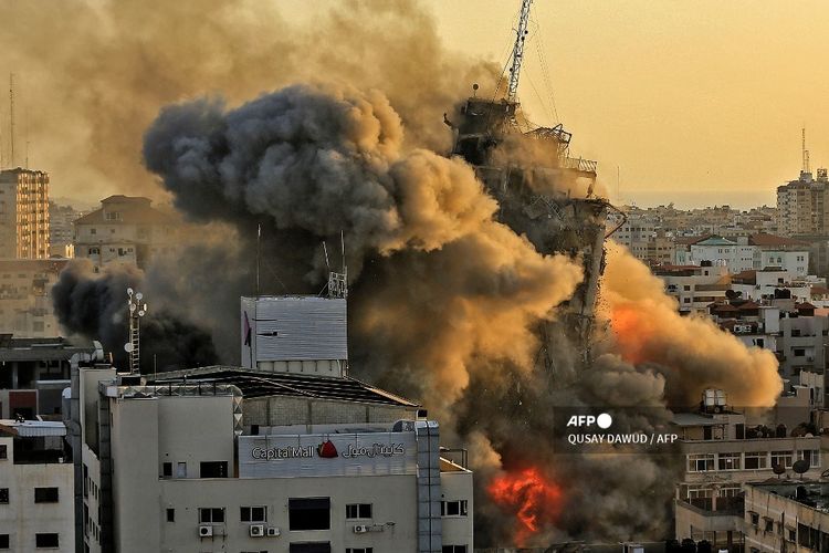 Asap tebal dan api membumbung dari menara Al-Sharouk saat runtuh setelah terkena serangan udara <a href='https://tribunmedan.cfd/tag/israel' title='Israel'>Israel</a>, di Kota Gaza pada 12 Mei 2021. 