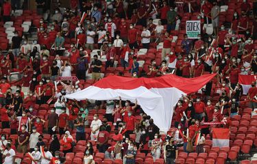 Suporter Timnas Indonesia memberikan sorakan dukungan pada pertandingan leg pertama final Piala AFF 2020 antara Indonesia vs Thailand di National Stadium, Singapura, Rabu (29/12/2021) malam WIB. Timnas Indonesia takluk 0-4 dari Thailand pada laga leg pertama final Piala AFF 2020.