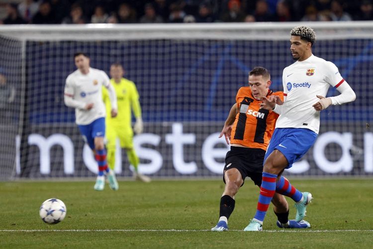 Penyerang Shakhtar Donetsk, Danylo Sikan (kiri), berebut bola dengan bek Barcelona, Ronald Araujo, dalam laga matchday keempat Grup H Liga Champions 2023-2024 yang digelar di Volksparkstadion, Hamburg, Jerman, pada Selasa (7/11/20230 malam waktu setempat. (Foto oleh Axel Heimken / AFP)