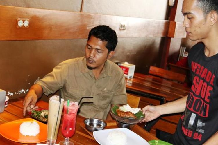 Pelayan menghidangkan makanan dan minuman pada pengunjung di DStar, Lhoksukon, Kabupaten Aceh Utara, Aceh.